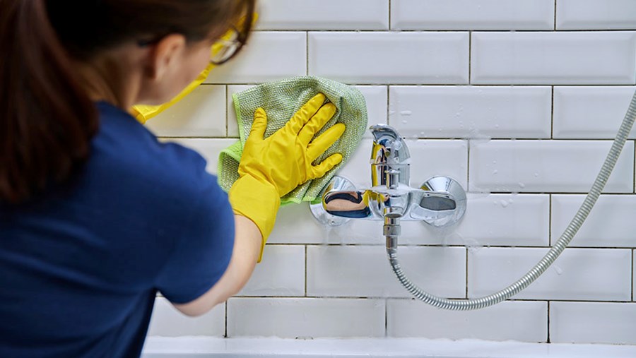 Eine Frau, die Schimmel in der Dusche wegputzt ACTIVE BEAUTY: dm Magazin für Beauty und Wohlbefinden plus Expertise vom dm friseur- & kosmetikstudio